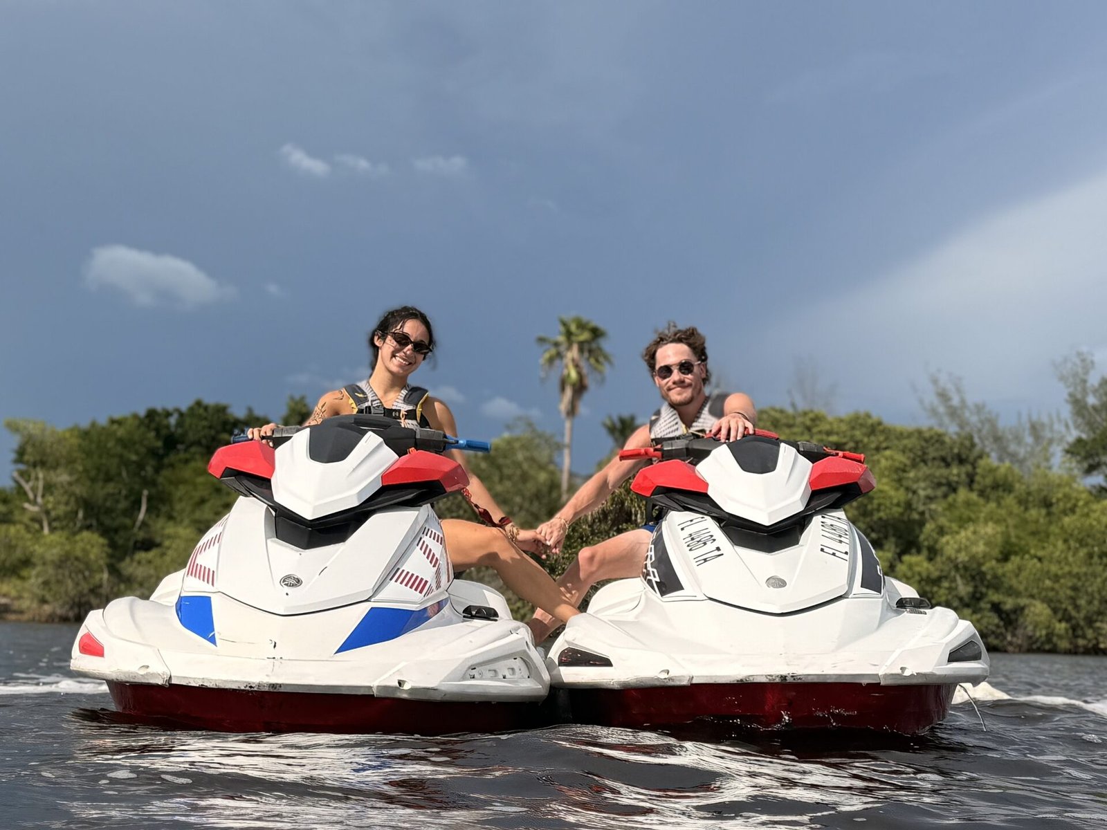 Couple on jet ski rentals near a palm tree in Fort Myers